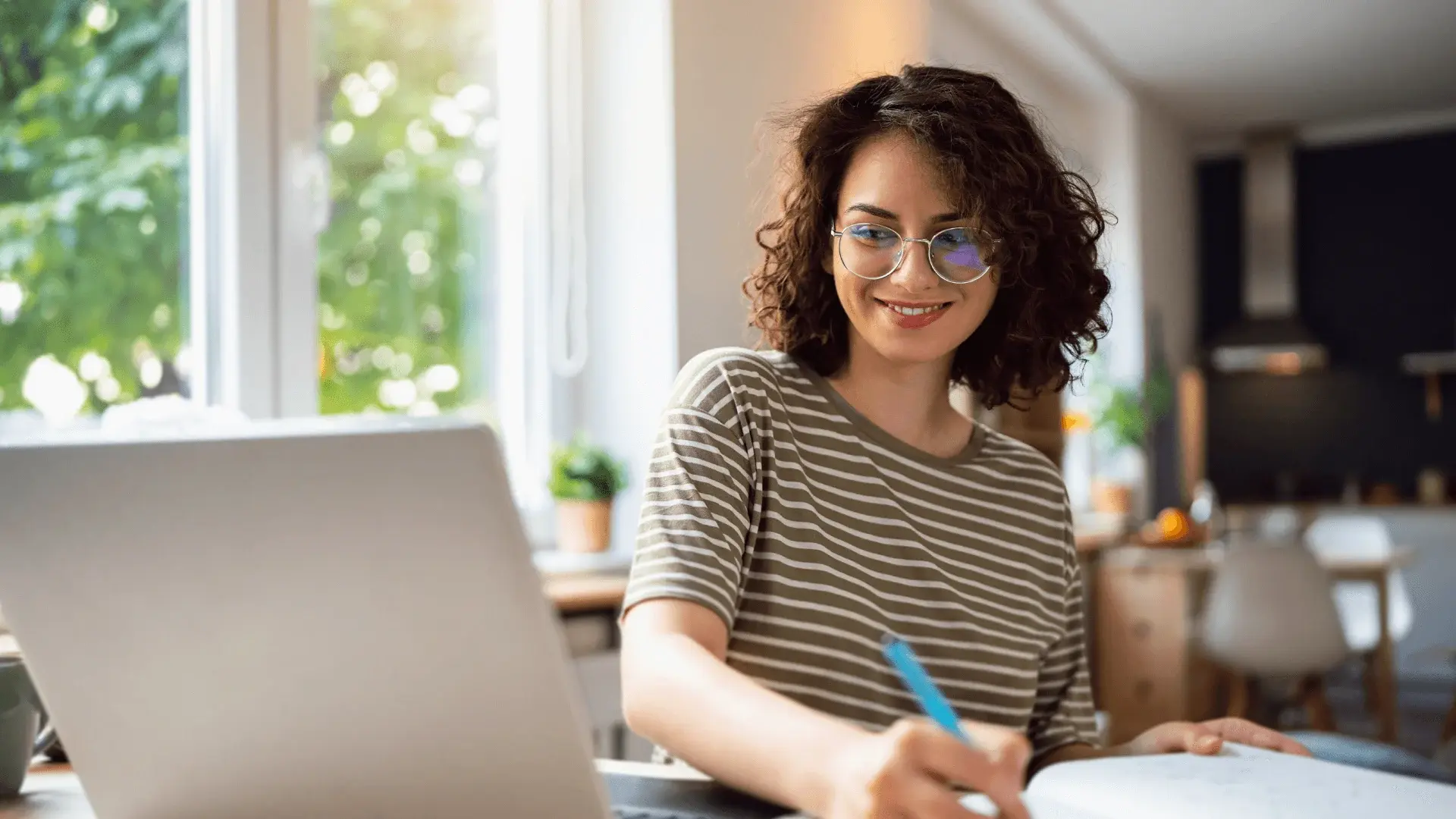 Woman sat at a desk studying something on a laptop