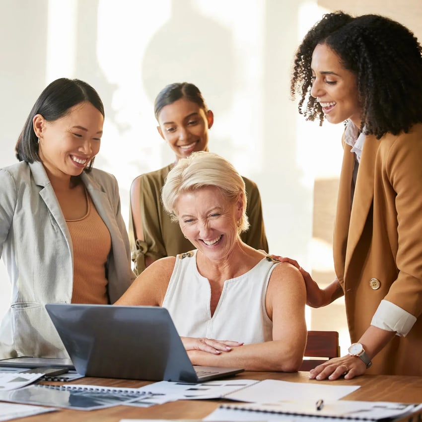 Women looking at a laptop and laughing.