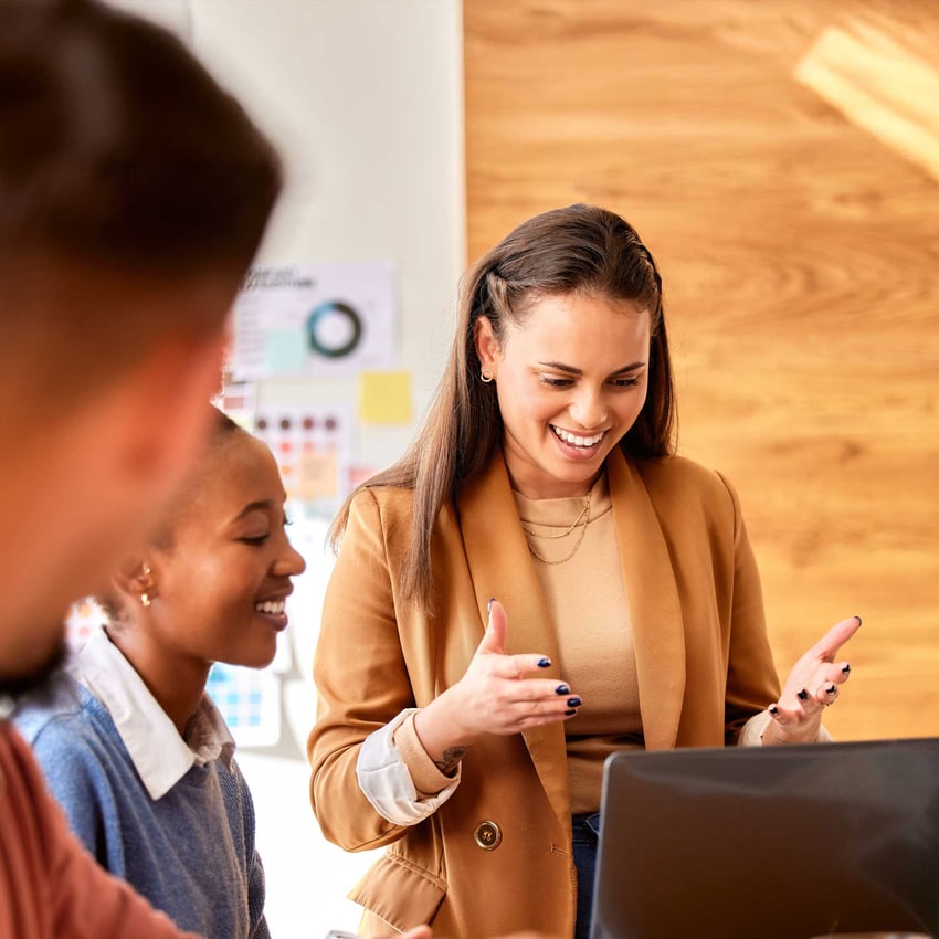 Woman in brown blazer leads a meeting