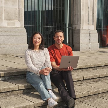 Two Walbrook and LIBF students sitting outside with a laptop