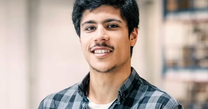 Smiling online student in grey check shirt