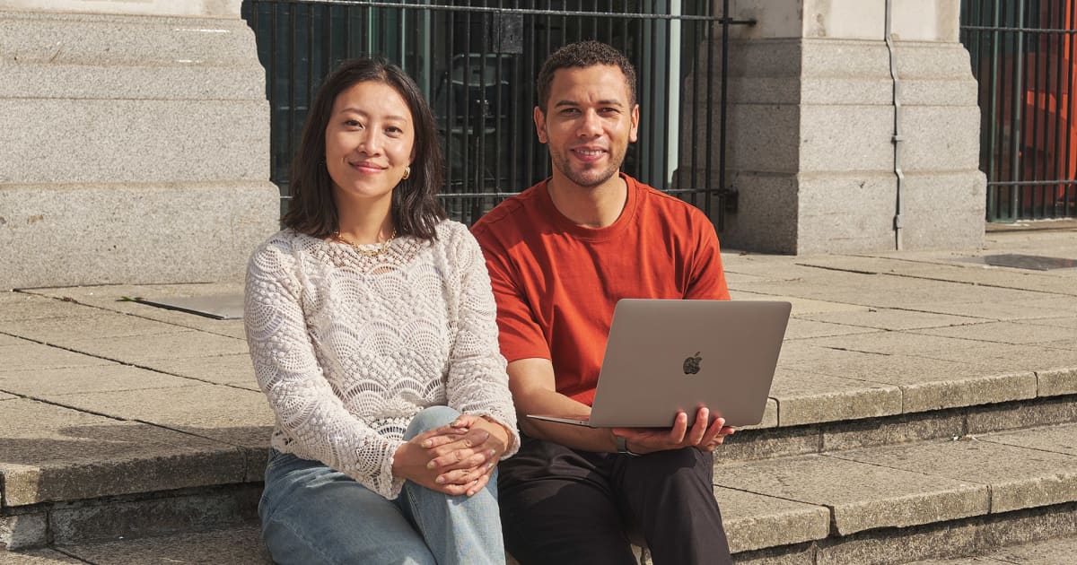 Two Walbrook and LIBF students sitting outside with a laptop
