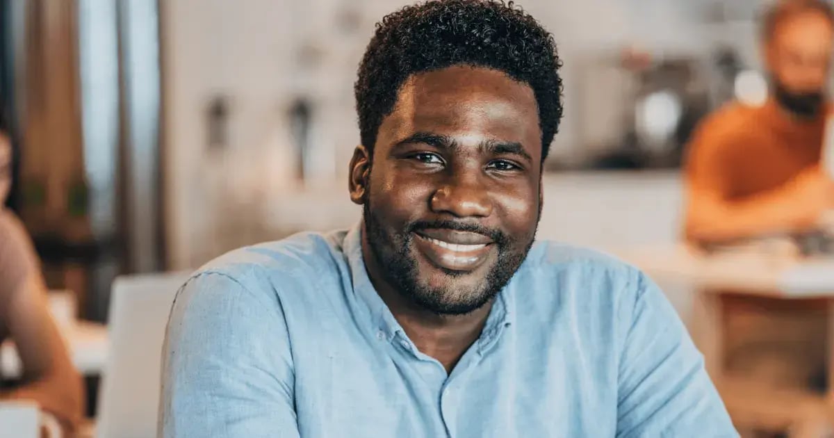 Smiling man in a shirt working in a financial management office after completing an accounting and finance course.