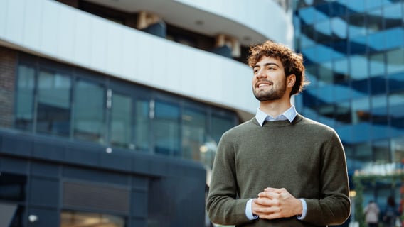 Man smiling and walking through corporate inner city environment