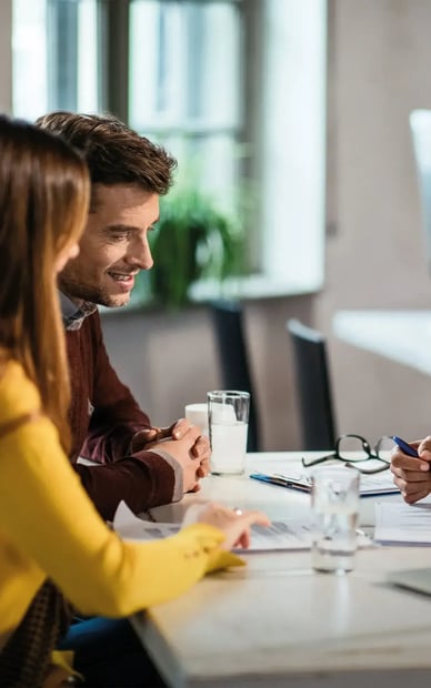 A woman providing paperwork to a young couple.