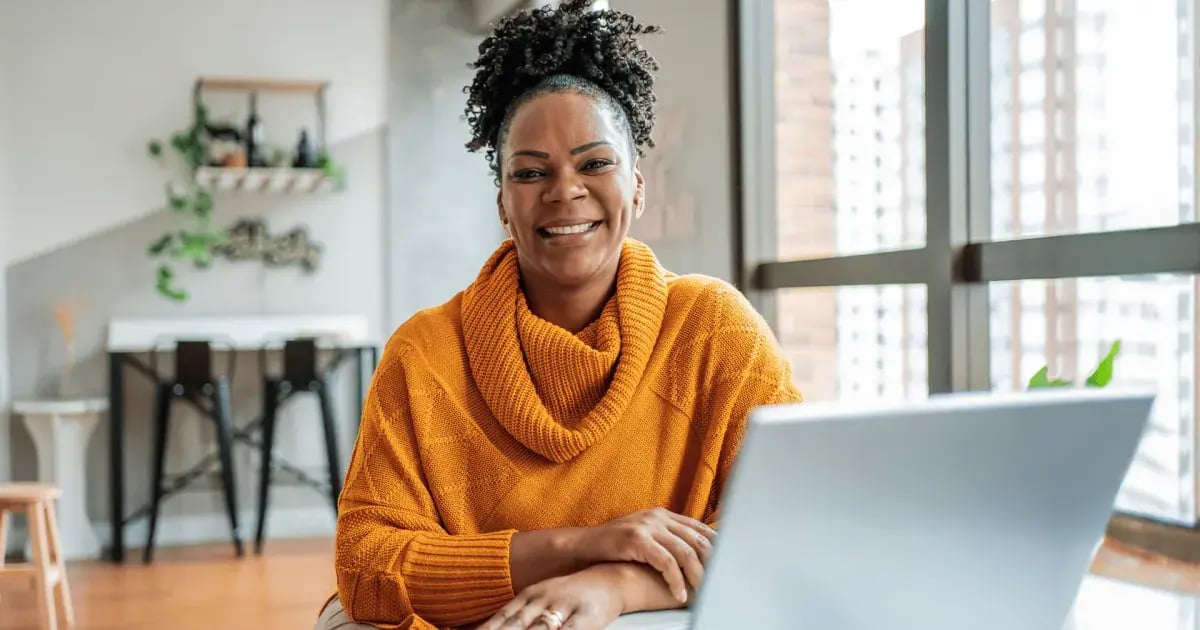 Smiling mature students studying online at a laptop from home